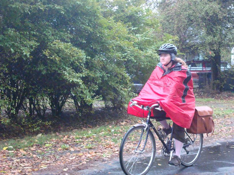 The author rides in the rain under a red poncho